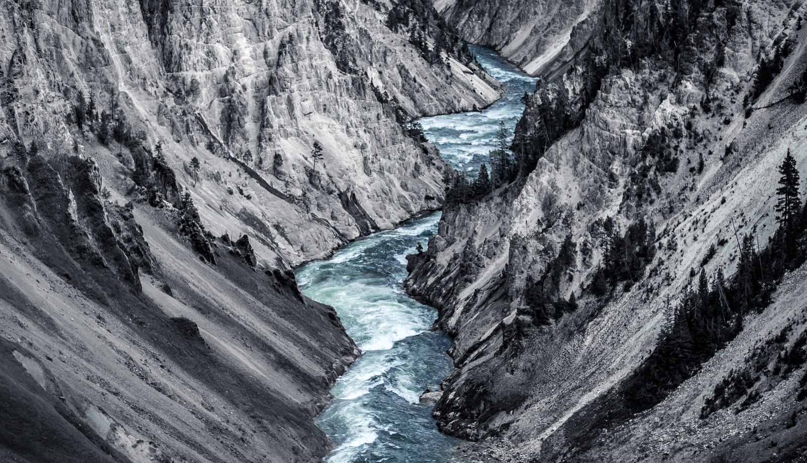 Blue water winds between steep pale canyon walls.